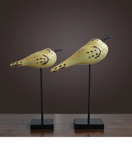 Détail de sculptures d'oiseaux en bois nordiques avec finition craquelée et base