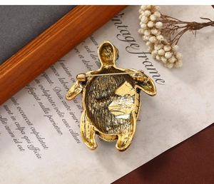 Detail of the back of a vintage sea turtle brooch with a secure safety pin closure
