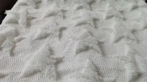 Close-up of white knitted pillowcase fabric showing plush star-shaped quilted textures
