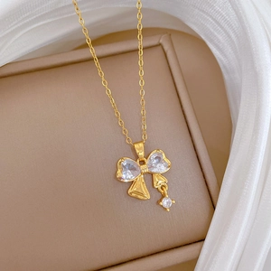Primo piano della collana in titanio dorato con ciondolo a fiocco e zirconi micro-incastonati