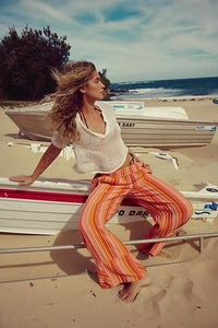 Détail du haut en tricot blanc et du pantalon large à rayures orange pour style de vacances