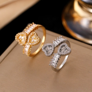 Macro shot of gold and silver bow-shaped heart rings with micro-pave zircons