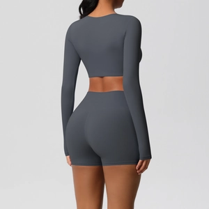 Back view of dark grey seamless yoga set featuring long sleeve crop top and high waist shorts