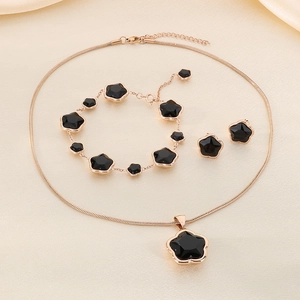 Rose gold stainless steel jewelry set featuring black four-leaf clover floral pendants