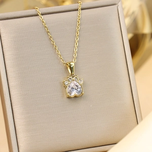 Détail du pendentif patte de chat doré 18K avec zircon cœur sur boîte à bijoux chic