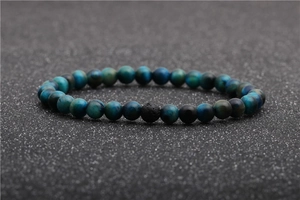 Macro shot of blue tiger eye beads and black lava stone on a minimalist stone bracelet