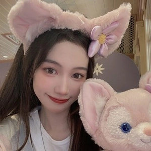 Detailed plush pink fox ear headband shown on a model with matching stuffed toy accessory
