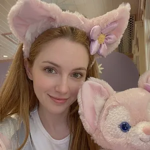 Dettaglio del cerchietto in peluche rosa con orecchie da volpe indossato da una modella