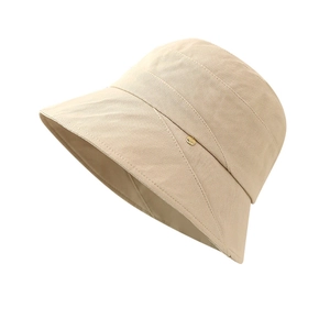 Minimalist beige canvas bucket hat with elegant gold metal logo for sun protection