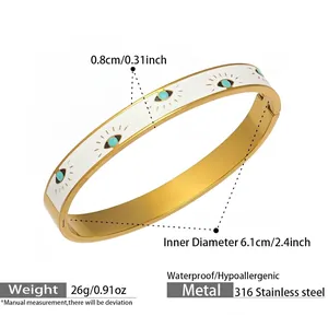Detail view of gold stainless steel bangle with white enamel and turquoise evil eye motifs