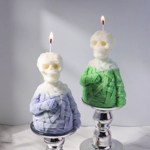 Detail of mummy shaped scented candles in purple and green with fine bandage texture