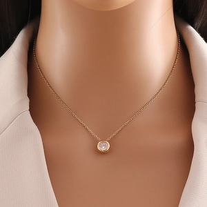 Elegant gold stainless steel necklace with a round zircon pendant on model neck