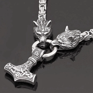 Gros plan détaillé du pendentif Marteau de Thor Mjölnir avec têtes de loup et chaîne