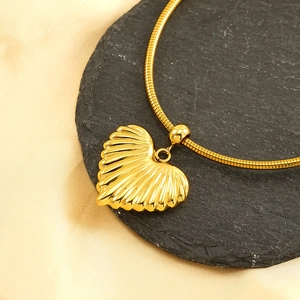 Pendentif coeur doré effet rayons de soleil sur chaîne serpent avec soie et pierre