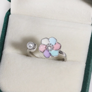 Detail of colorful enamel flower ring with zircon center and white pearl accent
