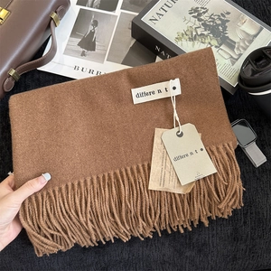 Close-up of brown cashmere-feel scarf with long tassels and elegant brand tags