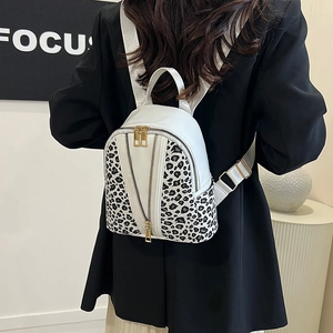 Mini white leather backpack with leopard print and gold zippers on model back