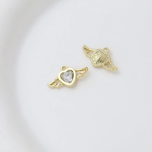 Macro shot of gold heart wing charms with zircons for DIY jewelry making