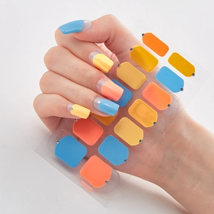 Detail of 3D laser gold foil nail stickers in blue and orange with small rhinestones
