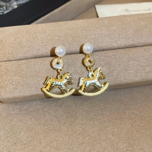 Vue détaillée de boucles d'oreilles cheval à bascule plaquées or 18 carats avec perles