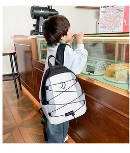 Moderne schoolrugzak voor kinderen met elastische koorden in een trendy café