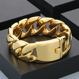 Close-up of a 24mm gold cuban link bracelet on black geometric blocks for hip-hop style