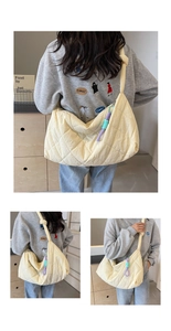 Detail of cream quilted tote bag featuring wrinkled texture and woven cord ornament