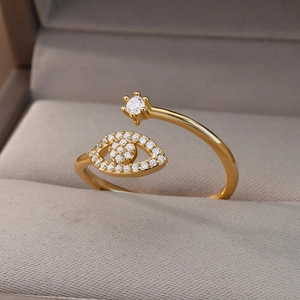 Detail of adjustable evil eye ring in gold with white zircons on a velvet box