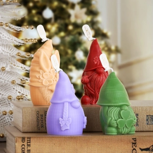 Detalle de cuatro velas de gnomos de colores con texturas 3D sobre libros antiguos