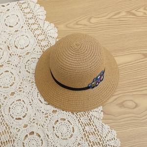 Détail du chapeau en paille avec écusson de voiture et ruban noir pour petit garçon