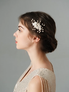 Detail of bridal hair comb with ceramic flowers and pearls on golden wire
