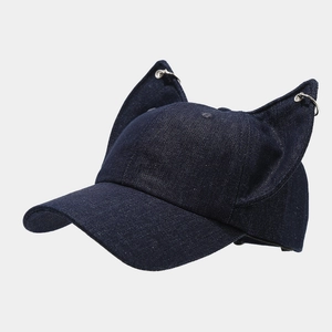 Detail of blue denim baseball cap with 3D cat ears and silver metal ring piercings