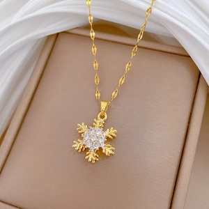 Detail of a rotating golden snowflake necklace with shimmering zircon crystals