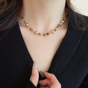 Detailansicht der Perlenkette mit Tigerauge und Muschelperlen an einem Modell getragen