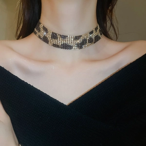 Detailed close-up of leopard print choker necklace with gold setting and rhinestones