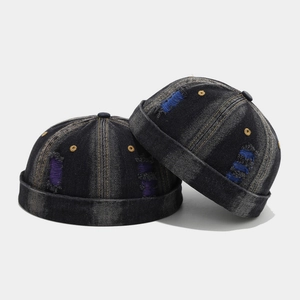 Distressed blue denim docker hat with vintage ripped holes and patchwork detailing