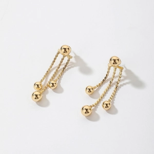 Detail of gold metal ball chain fringe earrings with reflective metallic finish and tassels