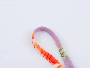 Detail view of colorful floral printed fabric with neat white stitching reinforcement