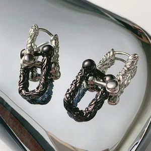 Gothic retro two-tone embossed earrings with horseshoe clasp on a mirror tray