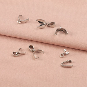Multiple silver stainless steel pinch bails for necklaces on a pink fabric background