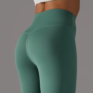 Detail of high-waist forest green yoga pants showing matte stretch fabric texture
