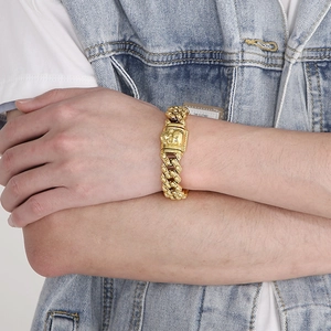 Men's punk style gold skull Cuban link bracelet in stainless steel worn by model