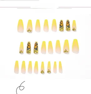 Macro detail of 24pcs yellow french ombre press-on nails with butterfly and rhinestones