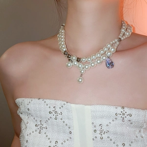 Detail einer Vintage-Doppelperlenkette mit lila tropfenförmigem Edelstein-Anhänger