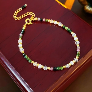 Macro shot of 18K gold plated pearl and crystal bracelet on a vintage wood jewelry box