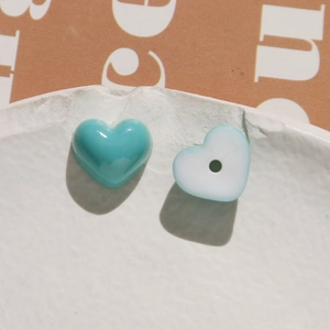 Macro shot of blue and white heart-shaped resin charms for DIY jewelry making