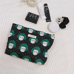 Detailed shot of canvas makeup bag with green girl graphic and simple wish label
