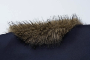 Close-up of fluffy brown faux fur collar on dark blue slim jacket with soft texture