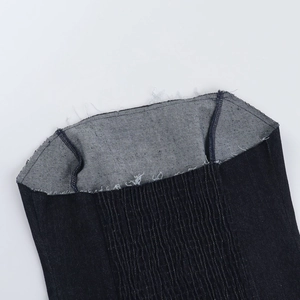 Détail d'un haut bustier en jean bleu foncé montrant la texture élastique et les coutures