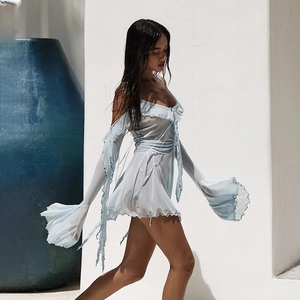 Dettaglio mini abito in mesh azzurro con bordi a balze ed eleganti maniche a campana